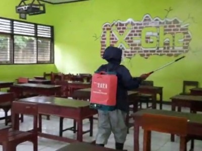Penyemprotan Desinfektan Sebelum Peserta Simulasi Datang Dalam kelas