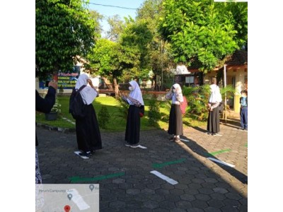 Siswa antri menunggu giliran cek suhu dan skrining